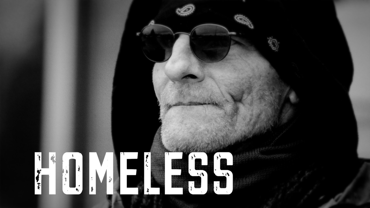 Black-and-white portrait of a man wearing sunglasses and a hood, with the title Homeless