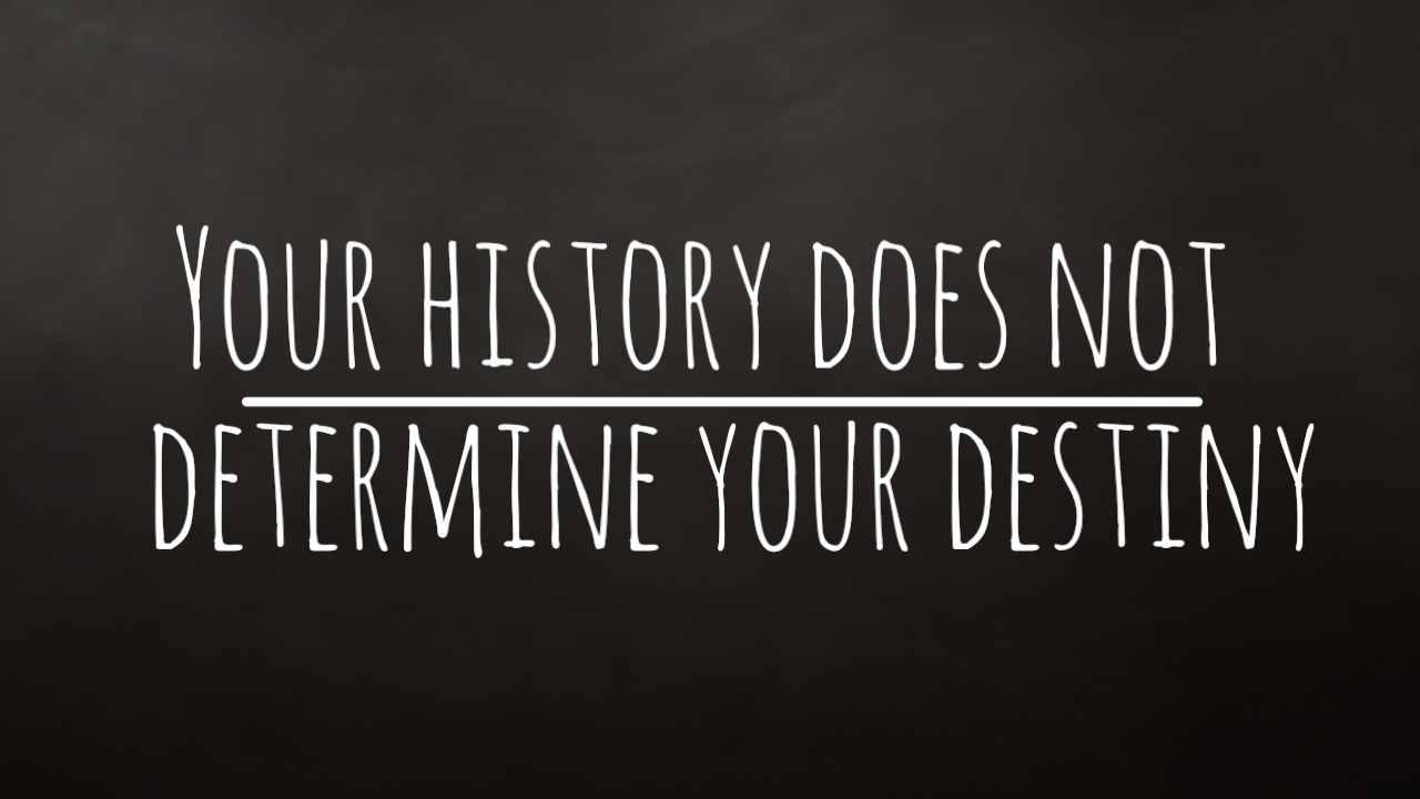 Your history does not determine your destiny in white lettering on a dark background